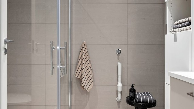 Badet har vegghengt toalett, dusjhjørne og opplegg for vaskemaskin.