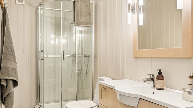 Badet er romslig og har flis på gulv og plater på vegger. Det er varmekabler i gulvet.