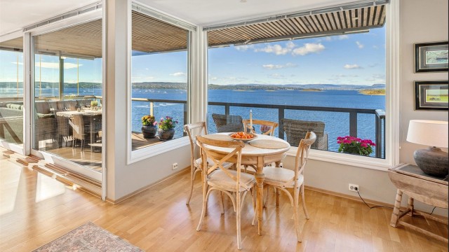Kjøkken med store vindusflater med fantastisk utsikt og god plass til spisebord ved vinduene