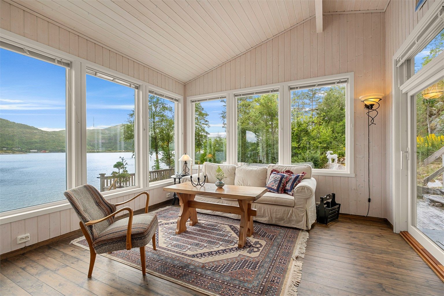 Store vinduer slipper sjøutsikten helt inn i stuen og sørger samtidig for rikelig med naturlig lys.