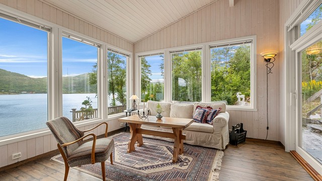 Store vinduer slipper sjøutsikten helt inn i stuen og sørger samtidig for rikelig med naturlig lys.