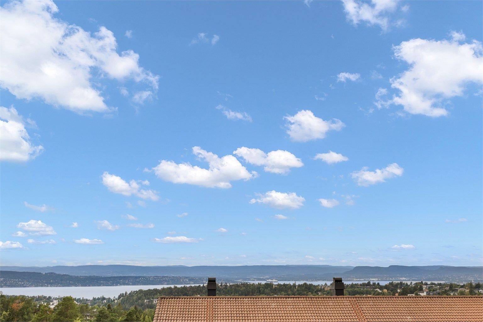 Flott utsyn over grønne fellesarealer, fjorden og Holmenkollen fra oppholdsrommene. 