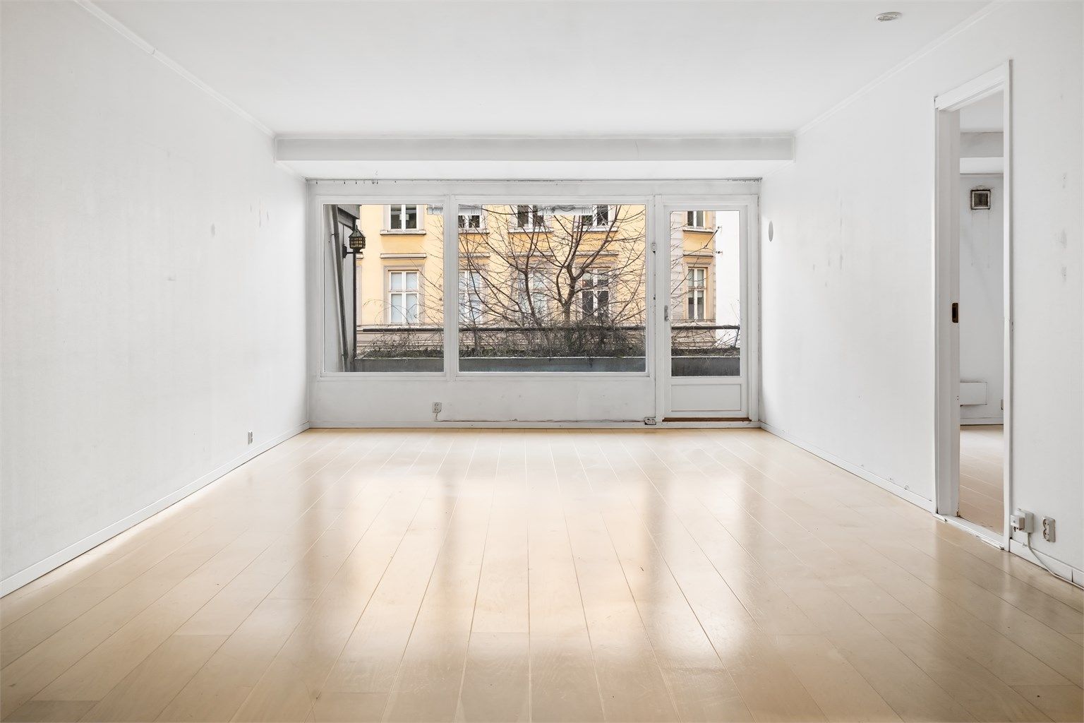 Romslig stue med plass til sofagruppe med tilhørende salongbord og tv-benk.