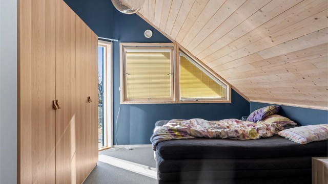 Det ene soverommet i andre etasje har teppegulv og utgang til en egen balkong på 2 m².