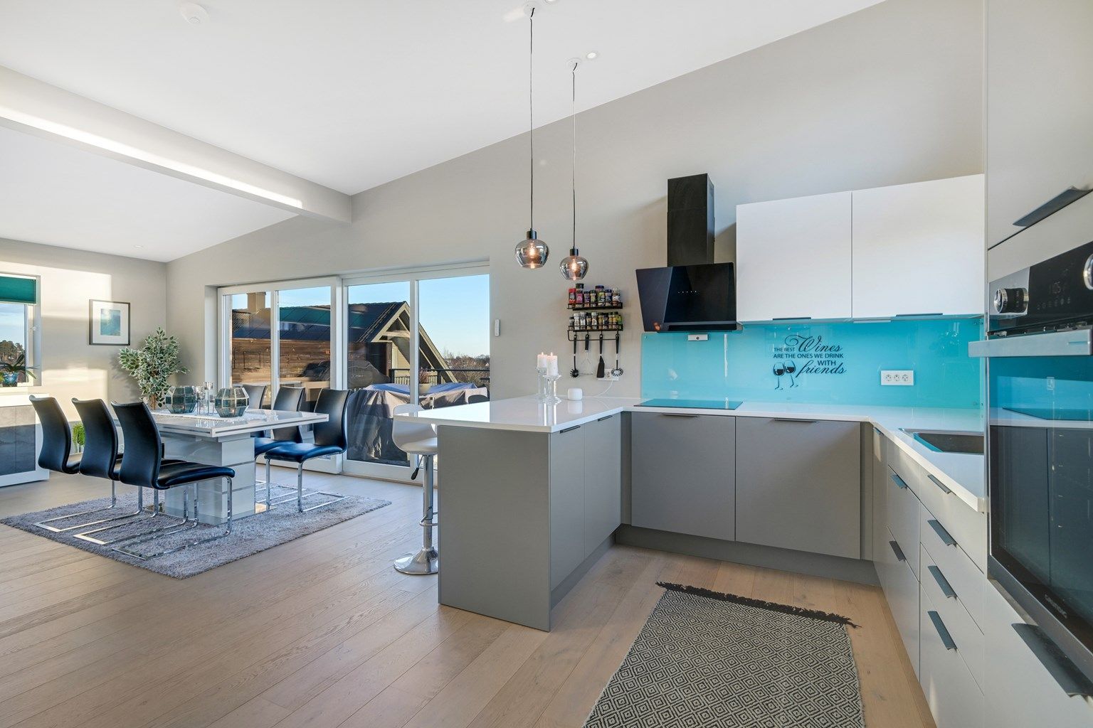 Et delikat kjøkken med stekeovn, kombiskap med frys og kjøl, oppvaskmaskin, integrert platetopp, samt en vegghengt ventilator