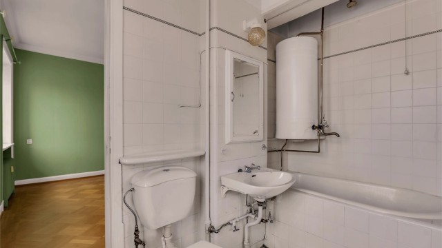 Eldre flislagt bad med toalett, servant og badekar. Badet er gitt TG 3.