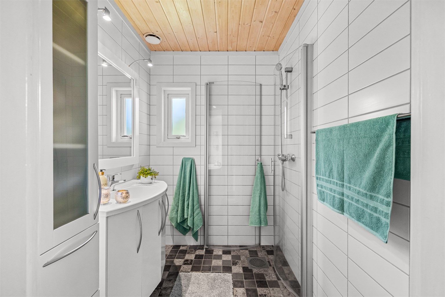Badet i hoveddelens første etasje har flislagt gulv med gulvvarme og dusjhjørnet.