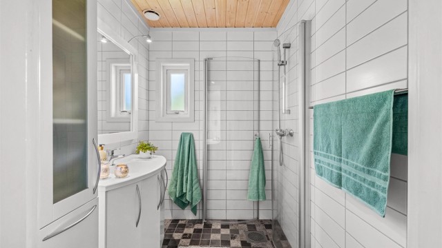 Badet i hoveddelens første etasje har flislagt gulv med gulvvarme og dusjhjørnet.