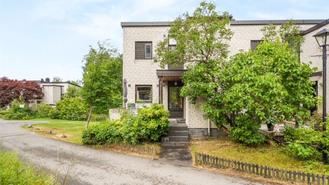 Enderekkehus med fasade i teglstein og tre.