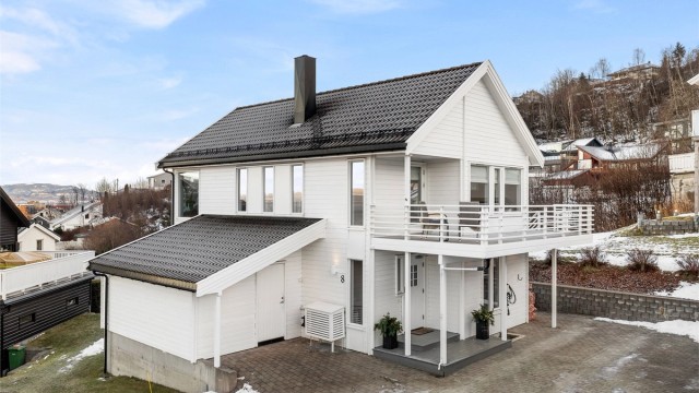 Boligen har flere biloppstillingsplasser i gårdsplassen. Elbil-lader ble installert i 2020 – godt tilpasset en moderne hverdag.