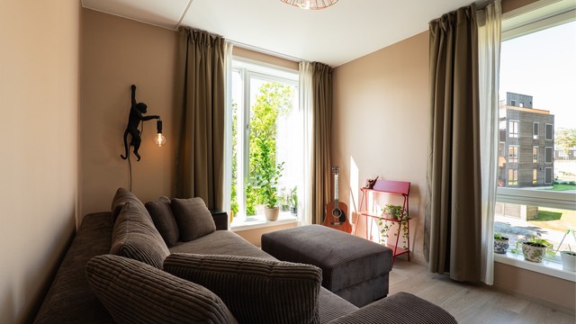 Vertikalstilte vinduer fyller hovedsoverommet med naturlig lys fra to vinkler.
