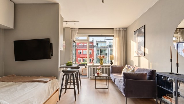 Gjennom dagen fylles rommet av naturlig lys som fremhever interiøret og gir boligen en varm stemning.