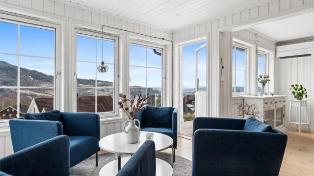 Romslig og lys stue med utgang til balkong og delvis innglasset vinterhage.