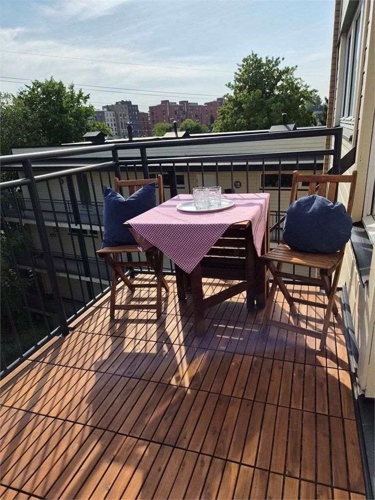 Balkonggulv er nå renovert. Gulvet er belagt terrasseheller i hardtre. Bilde tatt av selger