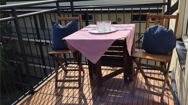 Balkonggulv er nå renovert. Gulvet er belagt terrasseheller i hardtre. Bilde tatt av selger