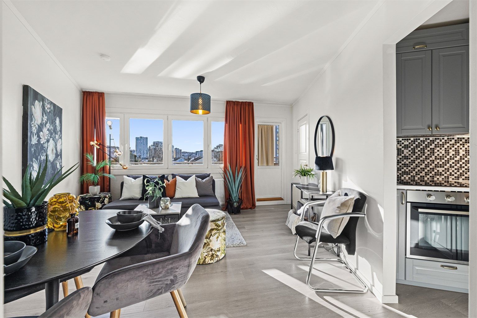 Den åpne løsningen mellom stue og kjøkken gir en sosial og inkluderende atmosfære.