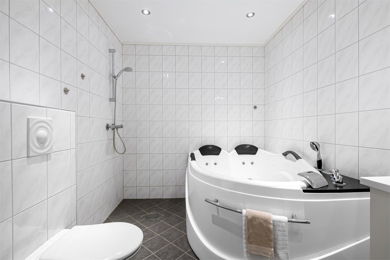 Baderommet er utstyrt med både separat dusj i hjørne og innbygget badekar.