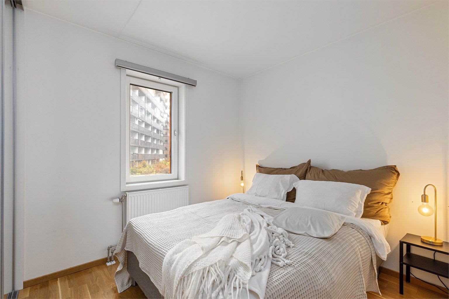 Soverom med parkett på gulv og radiator tilknyttet felles varmesentral. 