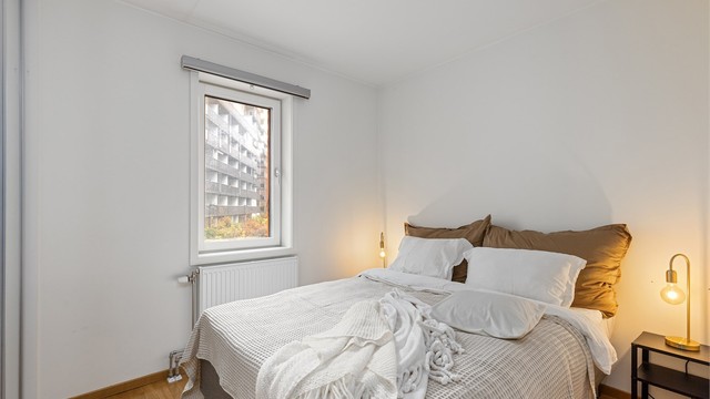 Soverom med parkett på gulv og radiator tilknyttet felles varmesentral.