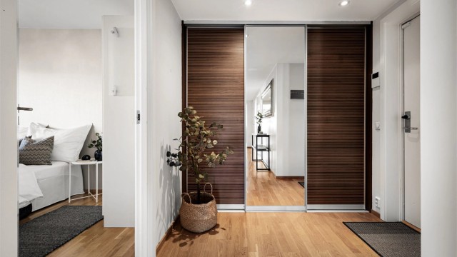 Romslig entré med en stor skyvedørsgarderobe med speilfronter, som gir rikelig med oppbevaringsplass.