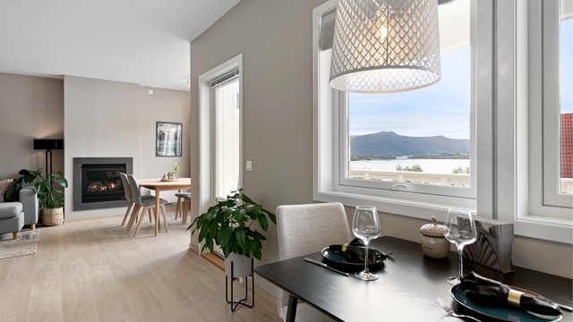 Hyggelig spiseplass på kjøkkenet med sjøutsikt gjennom vinduet.