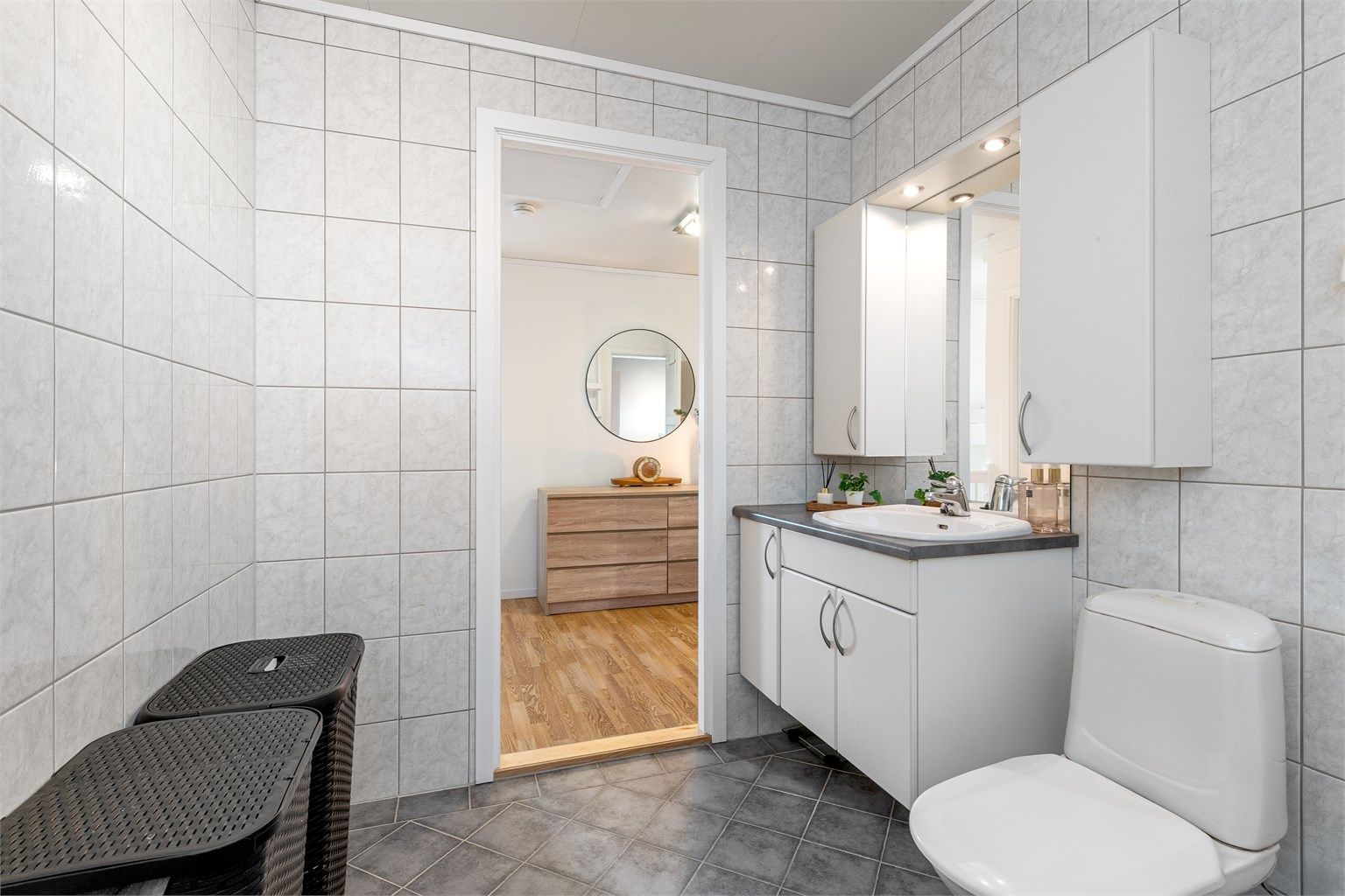 Baderomsinnredning med servant, speil med overlys og stikkontakt.