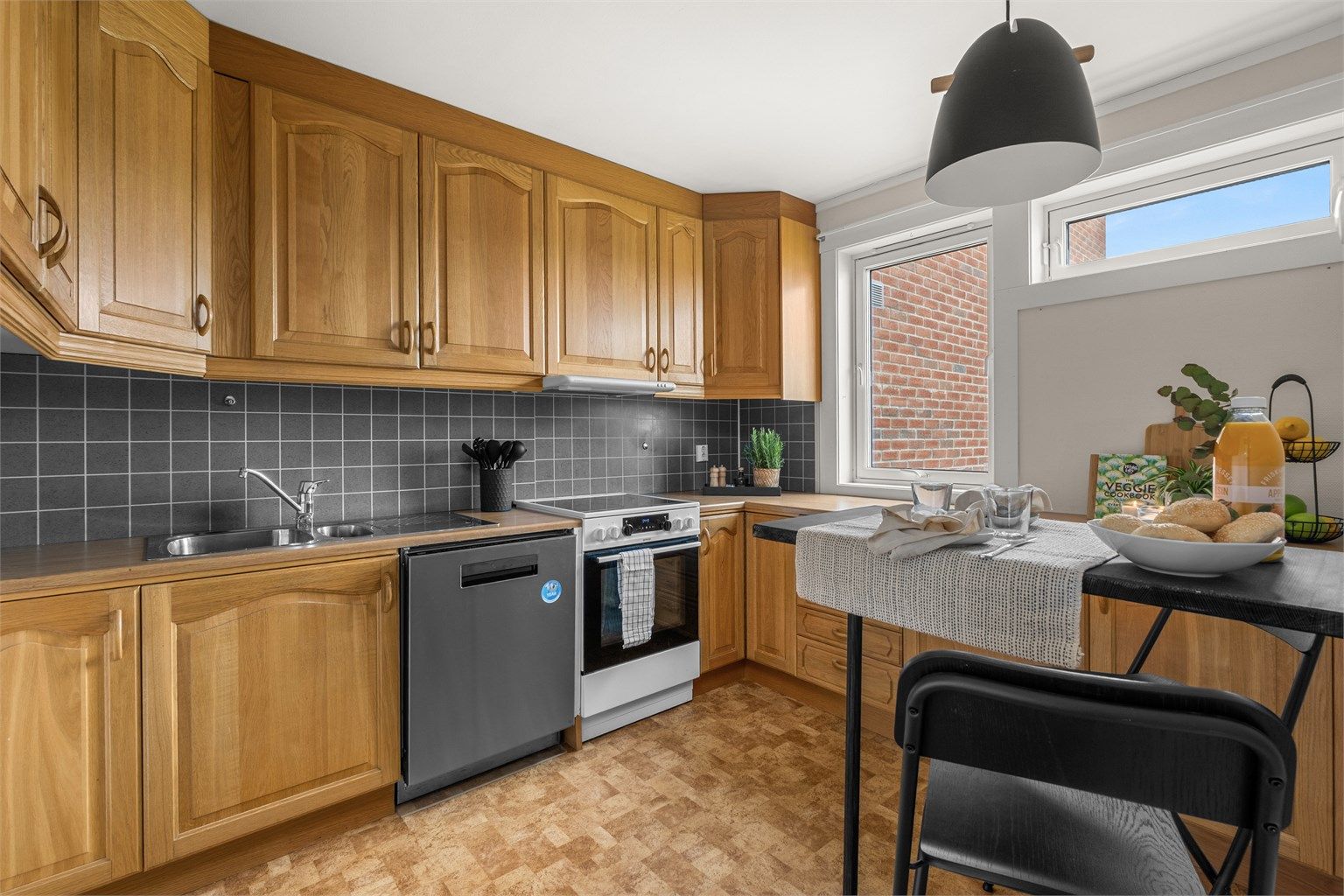 Kjøkkenet ligger naturlig tilbaketrukket fra stuen og er innredet med profilerte fronter og benkeplate av laminat. 