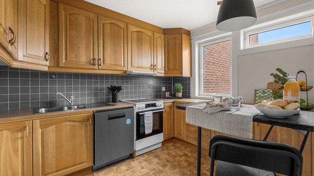 Kjøkkenet ligger naturlig tilbaketrukket fra stuen og er innredet med profilerte fronter og benkeplate av laminat.