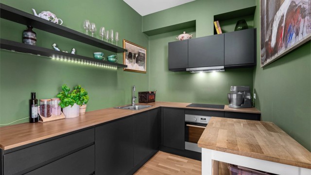 Moderne stilfult kjøkken med god benkeplass kombinert med åpne hyller, skuffer og overskap. Skap er malt i fargen Studio Green fra Farrow&Ball