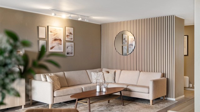 Vegger er i en moderne og fin fargetone, det er satt opp spilevegg på den ene kortveggen og det er fin laminat på gulv.