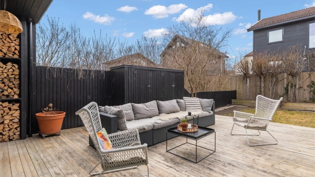 Skjermet terrasse utenfor stuen med adkomst til hagen