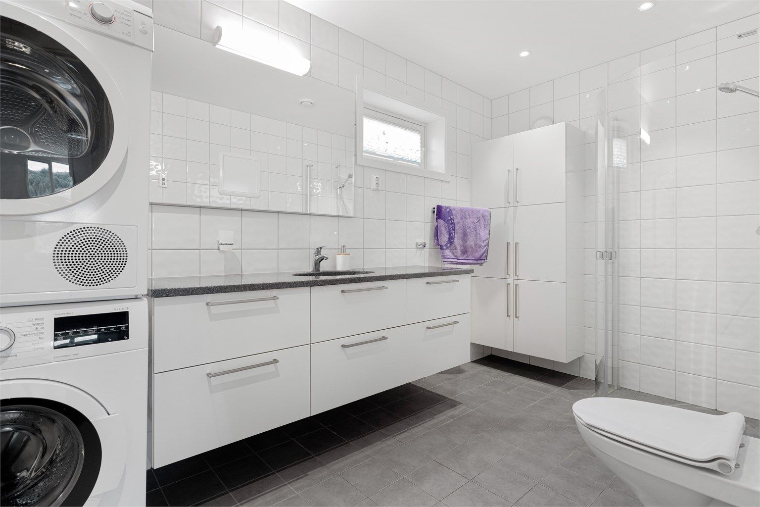 Stort flislagt bad på ca 6,5 kvm. med uttak for både vaskemaskin og tørketrommel. 