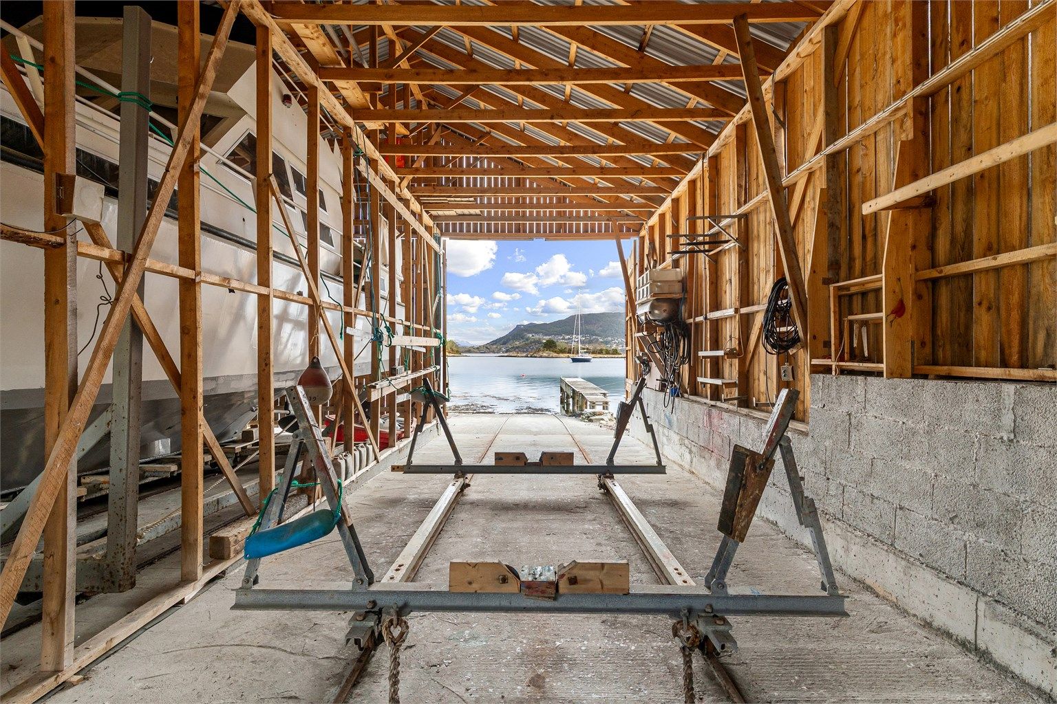 Innvendig er naustet utstyrt med elektriske vinsjer og skinner for enkel sjøsetting. Den gode takhøyden på opptil 4,95 meter gir plass til selv større båter. Foto: Stian Wiik
