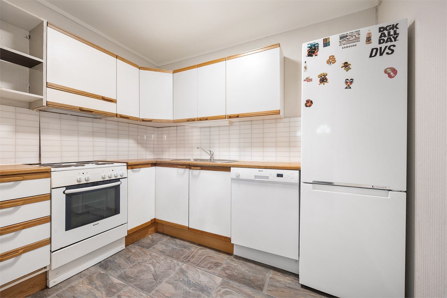 Kjøkkeninnredning med glatte fronter og laminert benkeplate.