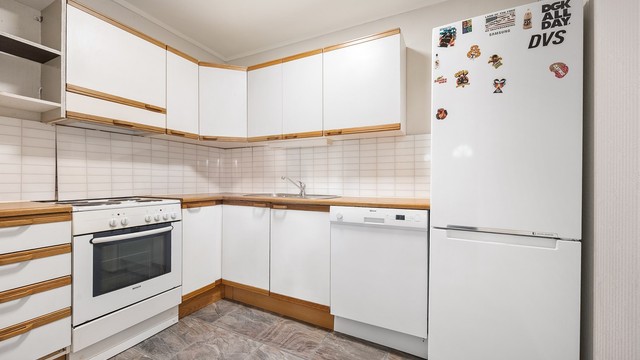 Kjøkkeninnredning med glatte fronter og laminert benkeplate.