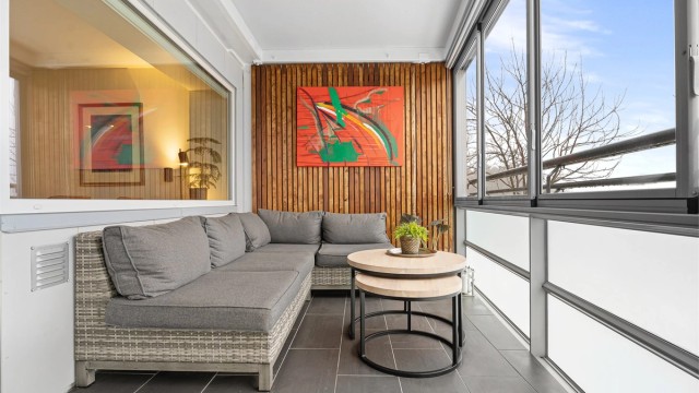 Lys og koselig inglasset balkong med plass til utemøbler og div