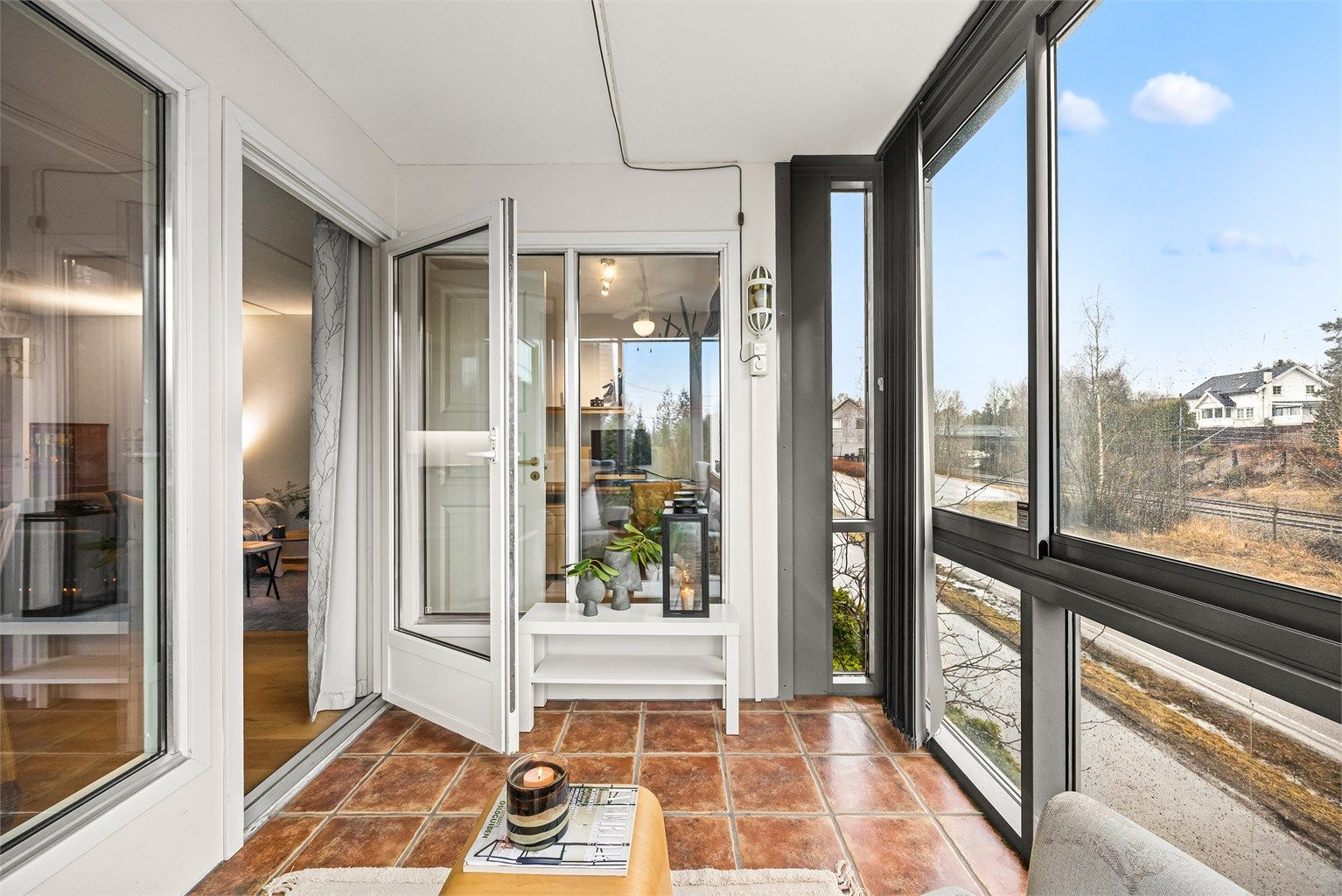 Utgang fra stuen til innglasset balkong som gir leiligheten et ekstra rom på sommerstid. Varme i gulvet gjør det lunt og godt her også på vår og høsten