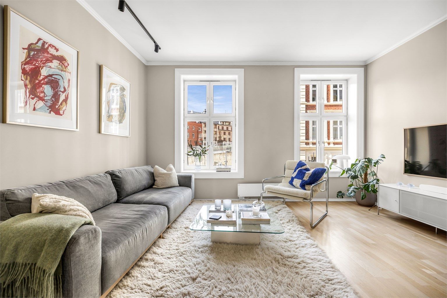 Store, høye vinduer slipper inn rikelig med dagslys i leiligheten.