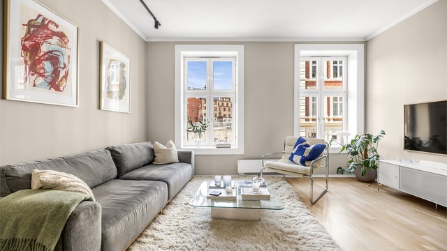 Store, høye vinduer slipper inn rikelig med dagslys i leiligheten.