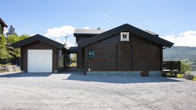 Adkomst, fasade og stort parkeringsareal i tilknytning til hytten