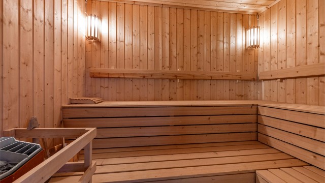 Romslig badstue med plassbygde benker og badstuovn fra byggeår