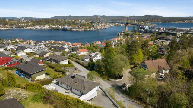 Tomta ligger litt for seg selv med den skogkledde åsen på andre siden av veien.