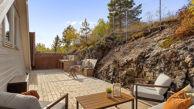 Romslig uteplass med plassbygd sittebenk og god plass til utemøblement.