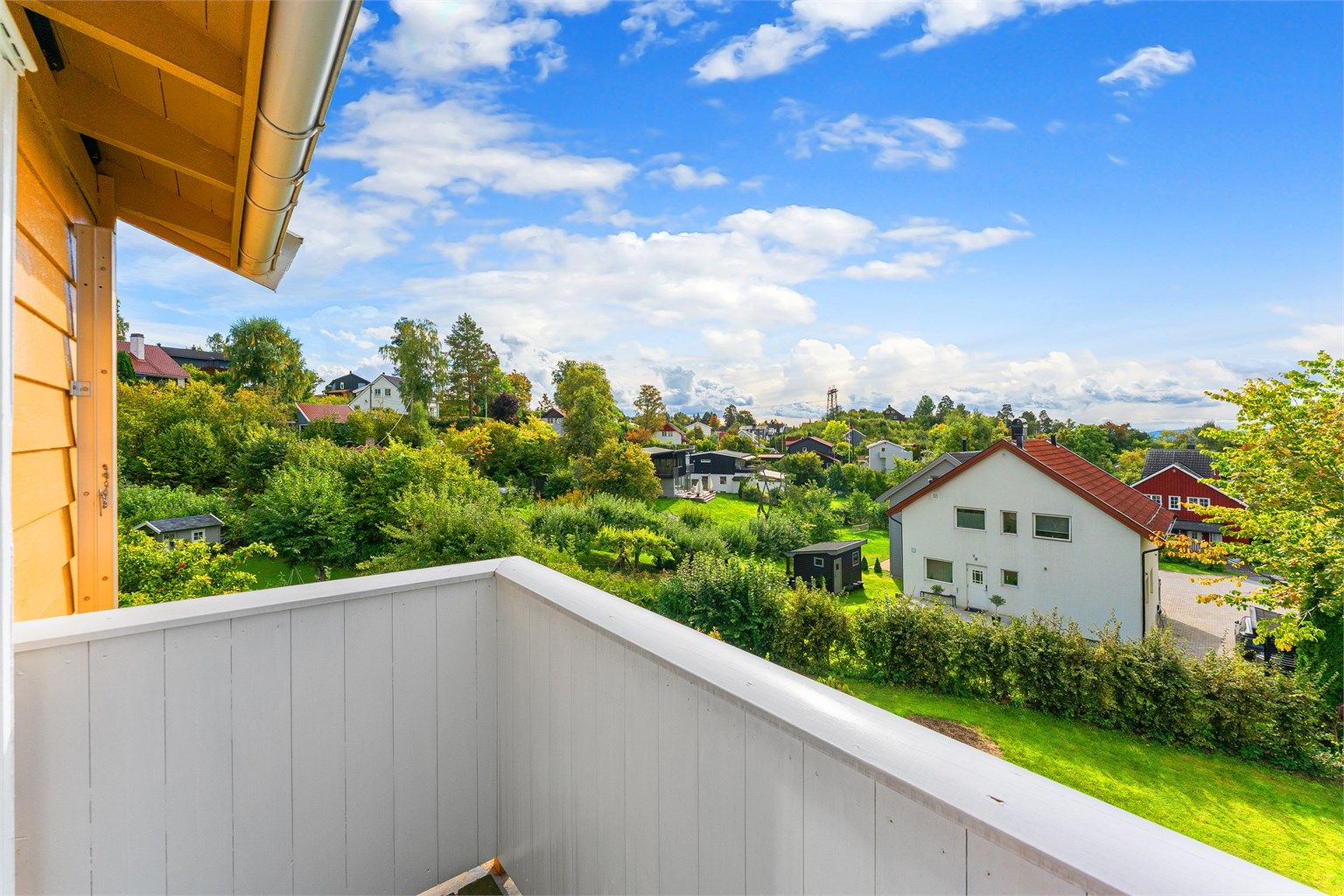 Utsyn over det grønne og frodige nærområdet fra balkongen i andre etasje.