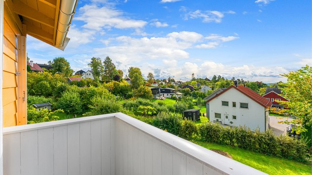 Utsyn over det grønne og frodige nærområdet fra balkongen i andre etasje.