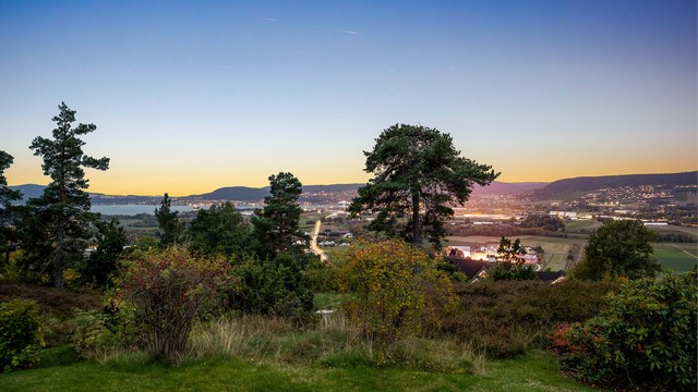 Utsikt over Lier, Drammenby og Drammensfjorden opplyst i kveldingen.