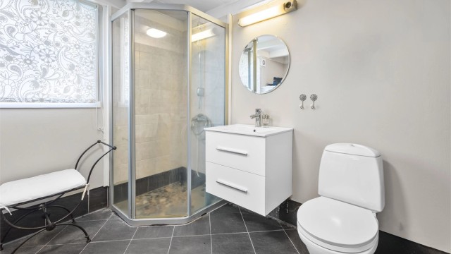 Badet i første etasje er utstyrt med toalett, servant og dusjkabinett.
