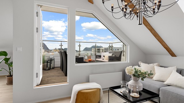 Balkongdøren fra 2011 og de store vindusflatene slipper inn rikelig med dagslys i stuen.