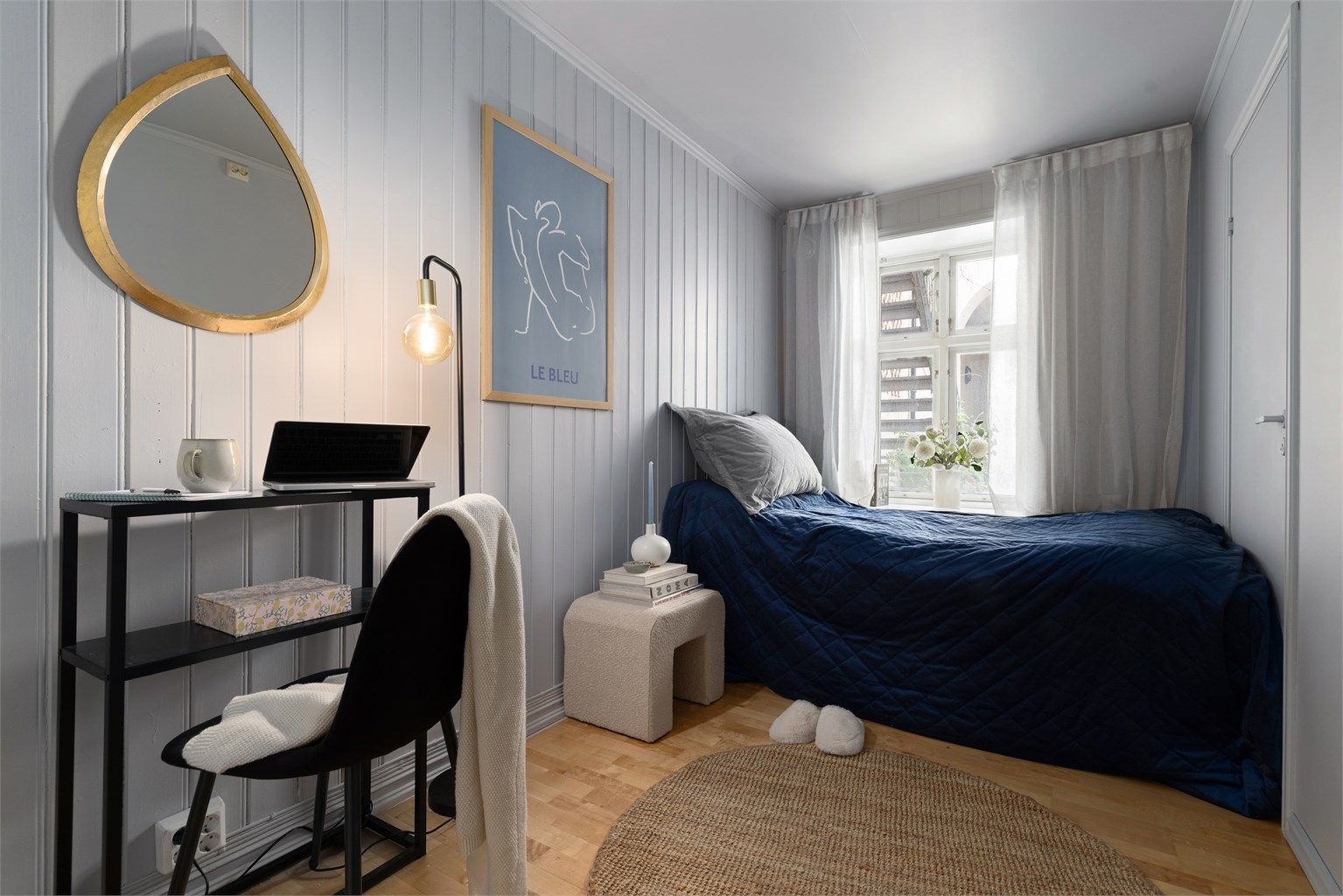 Lyst og luftig soverom med plass til seng, nattbord og skrivebord