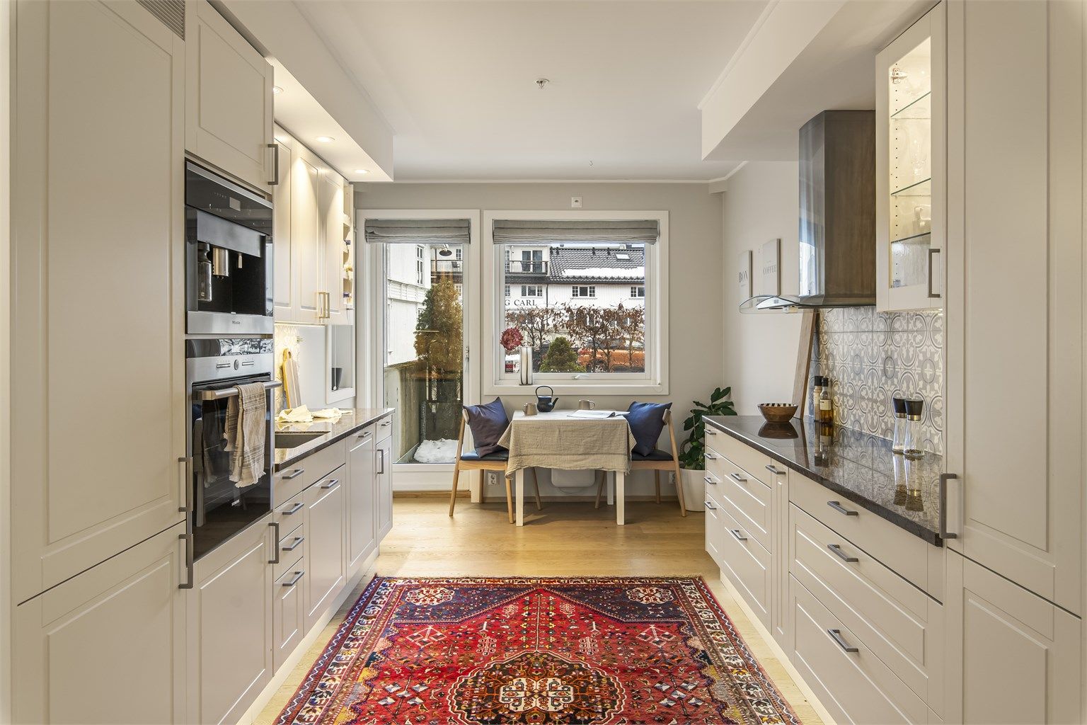 Smakfullt kjøkken med hvitprofilerte fronter og integrerte hvitevarer